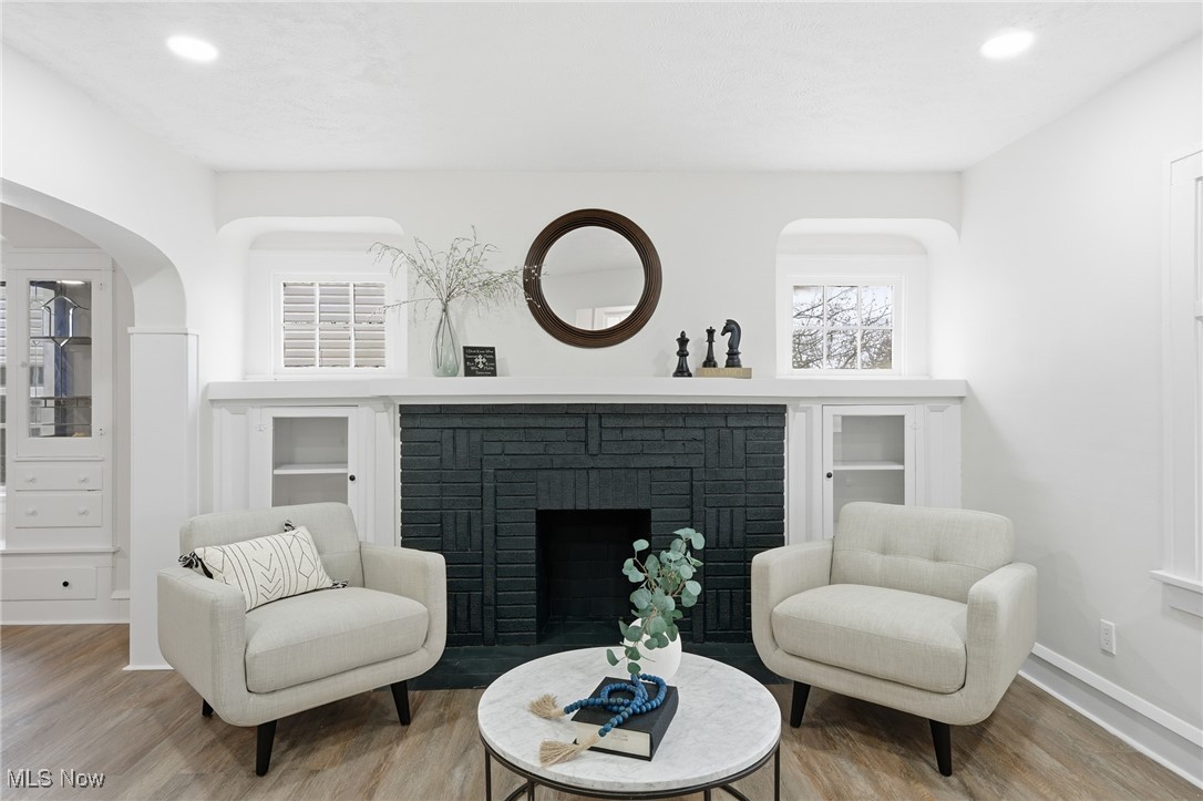 7911 Snow Road Parma, OH 44129 - Photo 4 of 44 Living area featuring a fireplace, arched walkways, wood finished floors, and recessed lighting