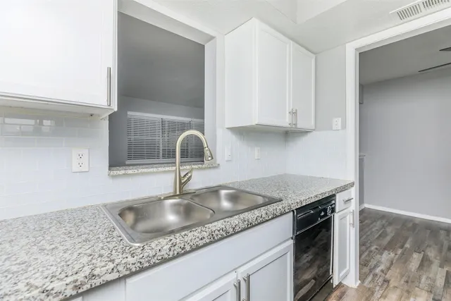 a kitchen with granite countertop a sink stove and refrigerator