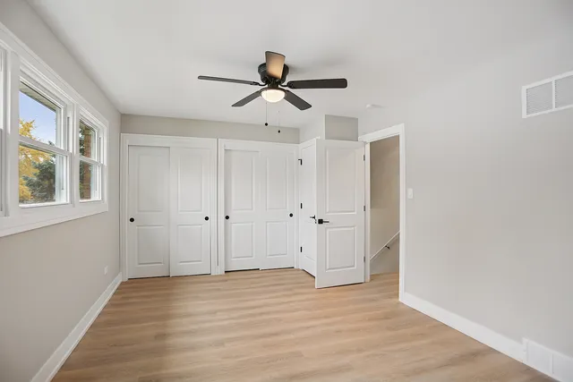 a view of empty room with wooden floor and window