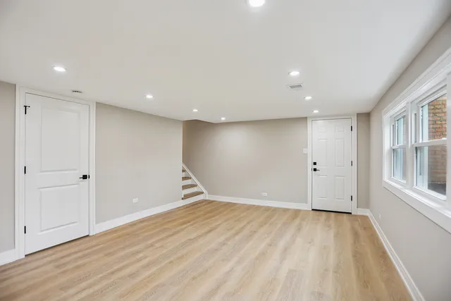 a view of empty room with wooden floor and windows