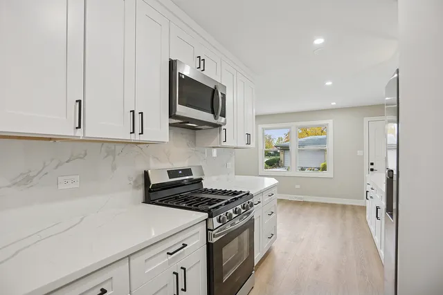 a kitchen with stainless steel appliances white cabinets and a stove
