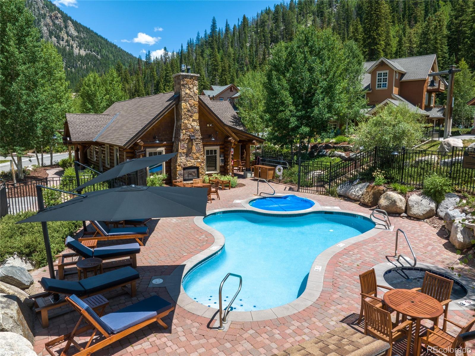 14 Arabella Drive, Unit 6516 Dillon, CO 80435 - Photo 28 of 39 a roof deck with table and chairs a barbeque with potted plants and large trees