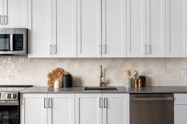 a kitchen with appliances a sink and cabinets