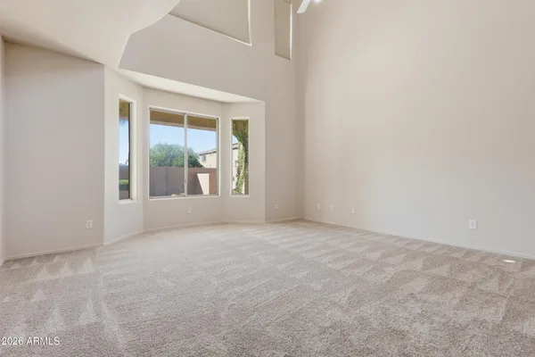 a view of an empty room with wooden floor fireplace and a window