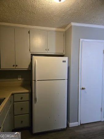 a view of a refrigerator in kitchen and cabinets