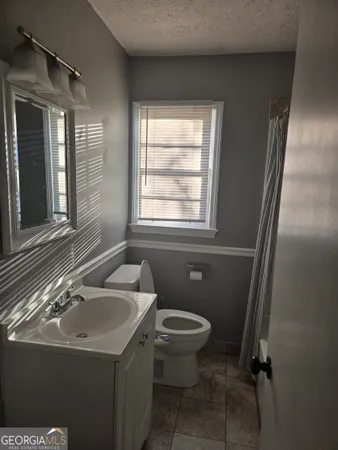 a bathroom with a sink toilet and window