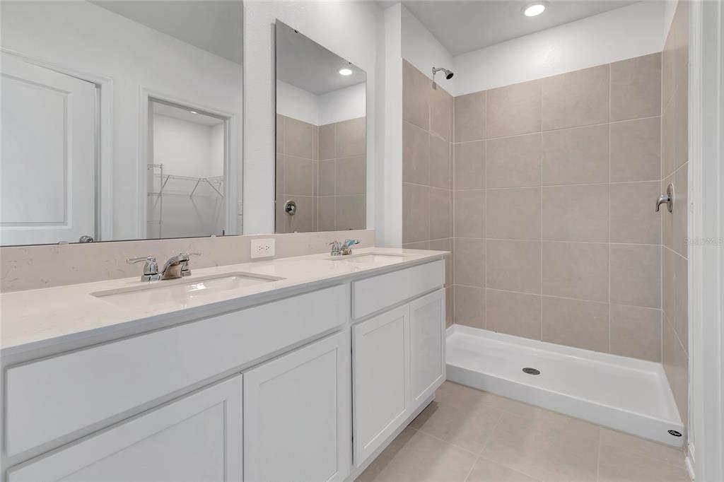 275 Puma Loop Groveland, FL 34736 - Photo 19 of 41 a bathroom with a shower sink vanity and mirror