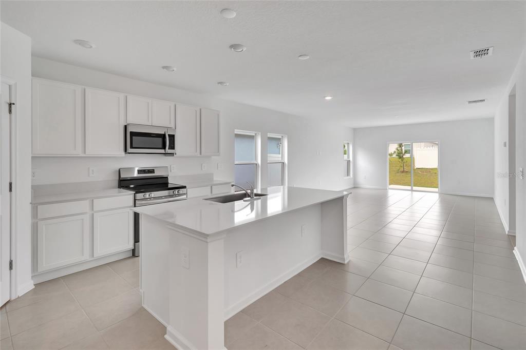 275 Puma Loop Groveland, FL 34736 - Photo 6 of 41 a kitchen with stainless steel appliances a stove a sink a microwave a refrigerator and cabinets