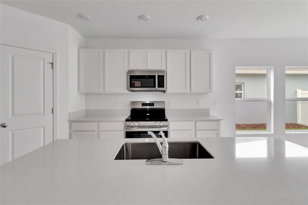 275 Puma Loop Groveland, FL 34736 - Photo 7 of 41 a kitchen with a refrigerator a stove a microwave and cabinets
