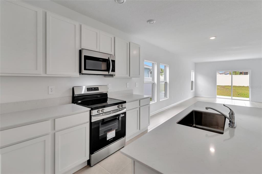 275 Puma Loop Groveland, FL 34736 - Photo 8 of 41 a kitchen with granite countertop a stove and a sink