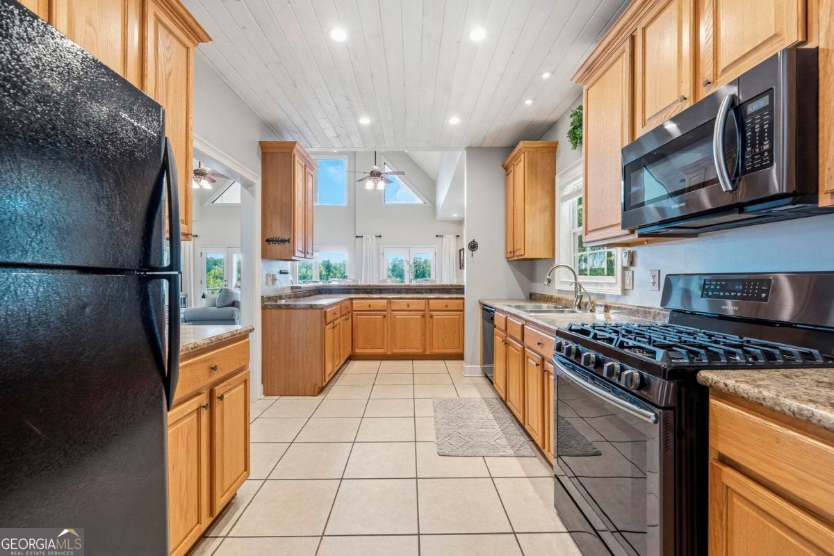 172 Mays Road Milledgeville, GA 31061 - Photo 22 of 54 a kitchen with stainless steel appliances granite countertop a stove top oven a sink a counter space and cabinets
