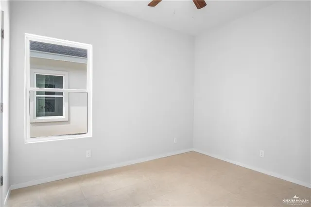 an empty room with a window and ceiling fan