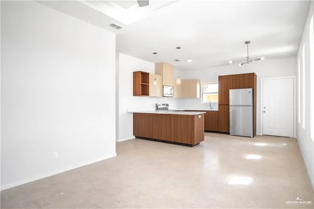 a large kitchen with a refrigerator and a sink