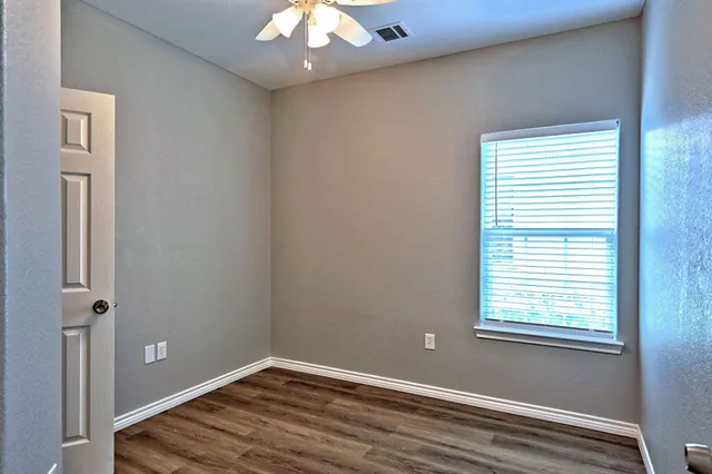 a view of empty room with wooden floor