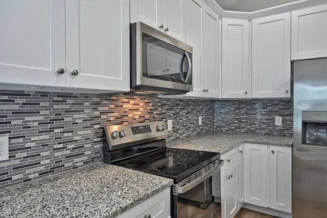 a kitchen with stainless steel appliances a stove a sink and cabinets