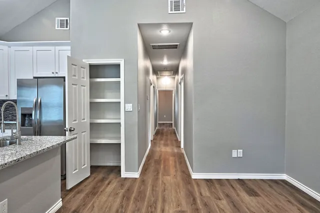 a view of a kitchen from the hallway with wooden floor