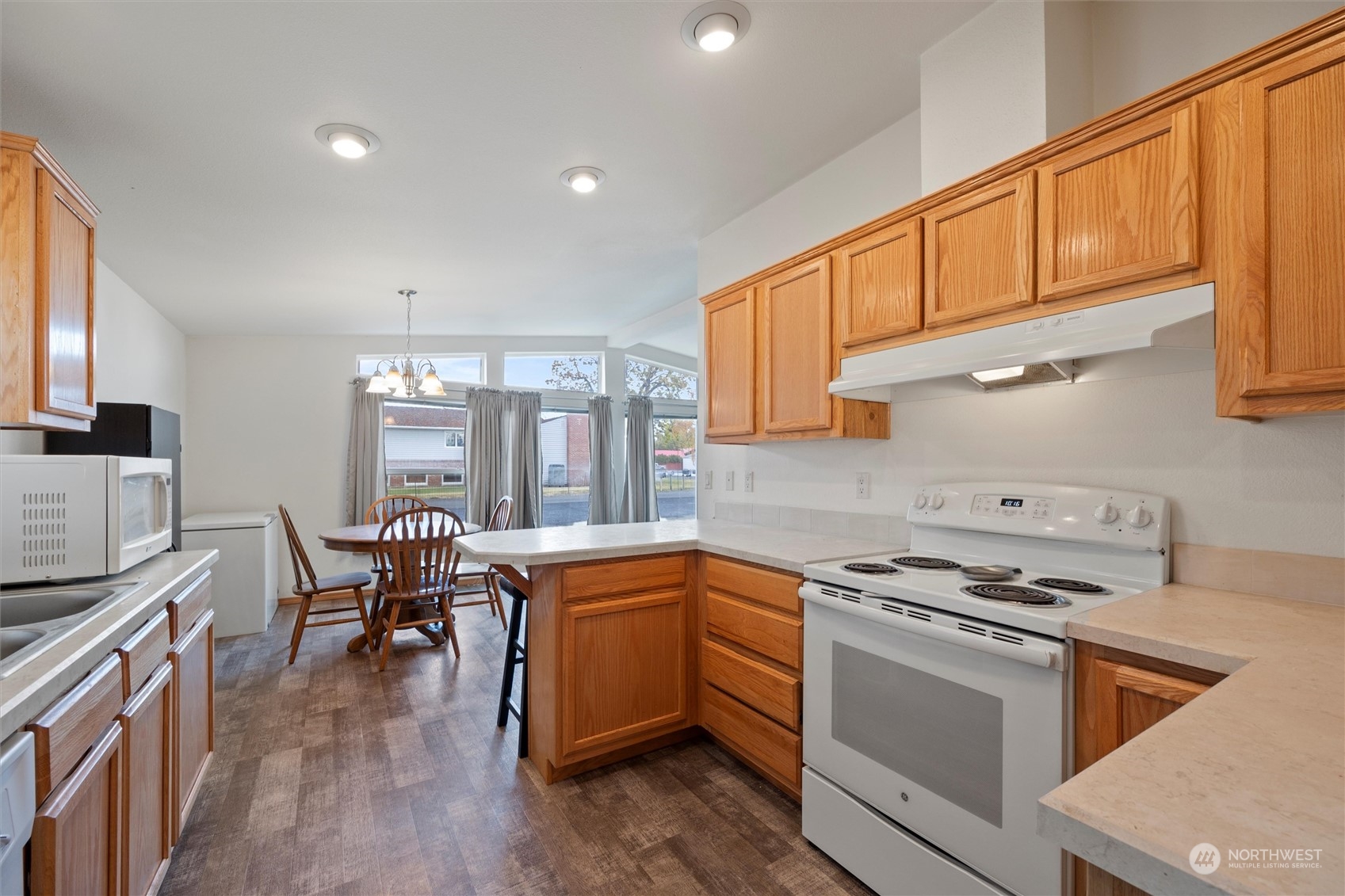 85 Second Street Touchet, WA 99360 - Photo 12 of 28 a kitchen with stainless steel appliances granite countertop a stove top oven a sink dishwasher and white cabinets with wooden floor