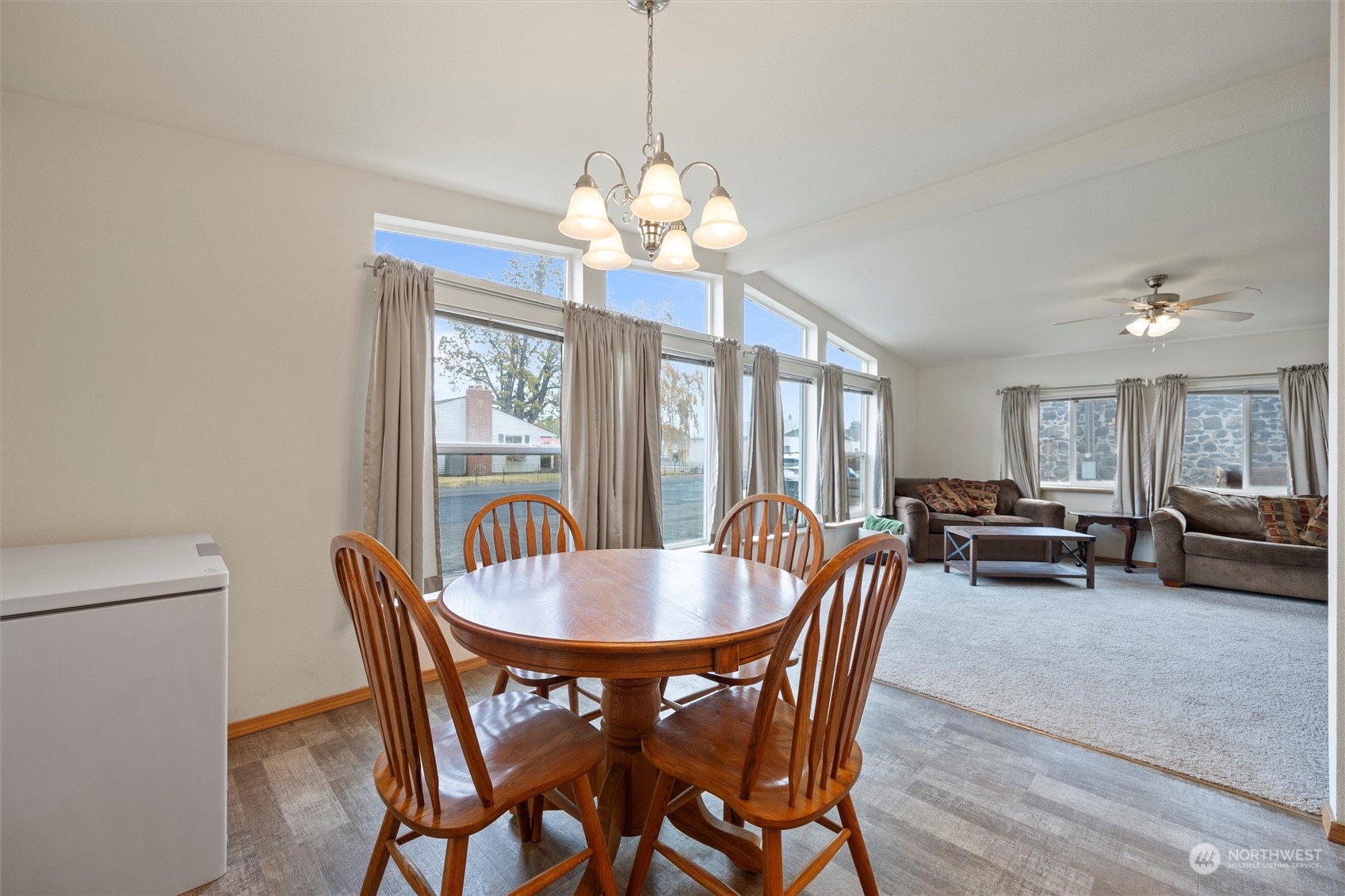 85 Second Street Touchet, WA 99360 - Photo 6 of 28 a dining room with wooden floor a chandelier a wooden table and chairs