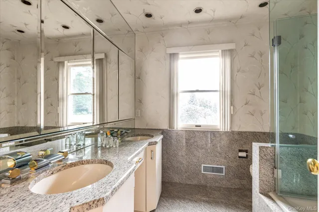 a bathroom with a granite countertop sink mirror and a bathtub