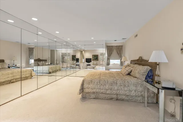 a spacious bedroom with a bed and a lamp