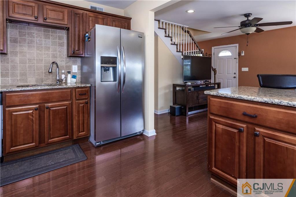 69 Ashley Road Edison, NJ 08817 - Photo 7 of 35 a kitchen with stainless steel appliances granite countertop a refrigerator a sink dishwasher a stove and white countertops with wooden floor