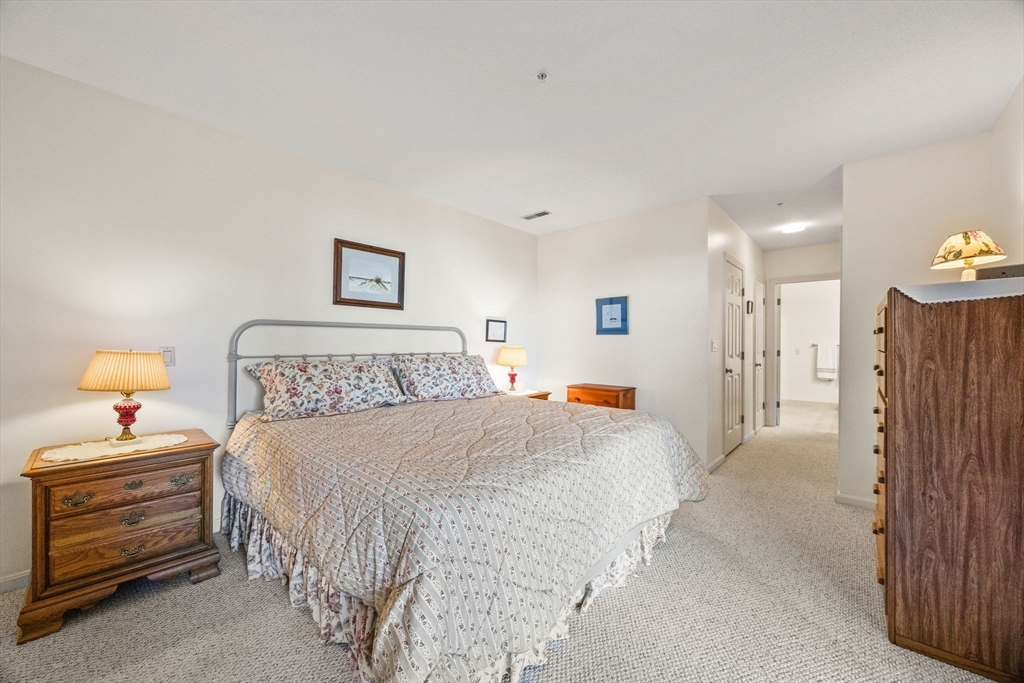 226 Kates Path, Unit 226 Yarmouth, MA 02675 - Photo 12 of 29 a bedroom with a bed and a lamp