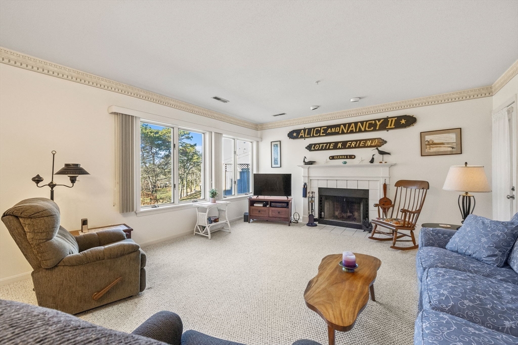 226 Kates Path, Unit 226 Yarmouth, MA 02675 - Photo 4 of 29 a living room with furniture a fireplace and a flat screen tv