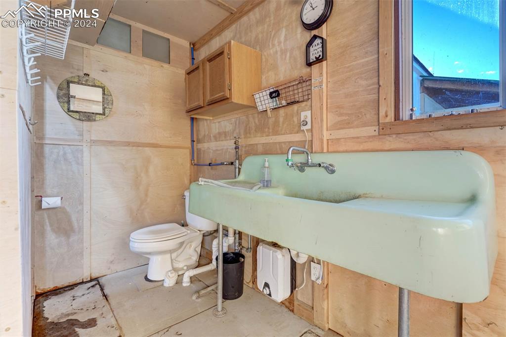 20880 Scott Road Calhan, CO 80808 - Photo 40 of 50 Bathroom featuring wood walls and toilet with running water