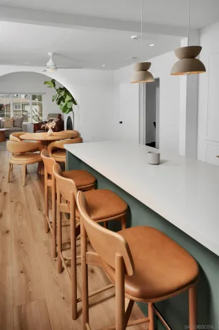 a kitchen with stainless steel appliances kitchen island a table and chairs in it