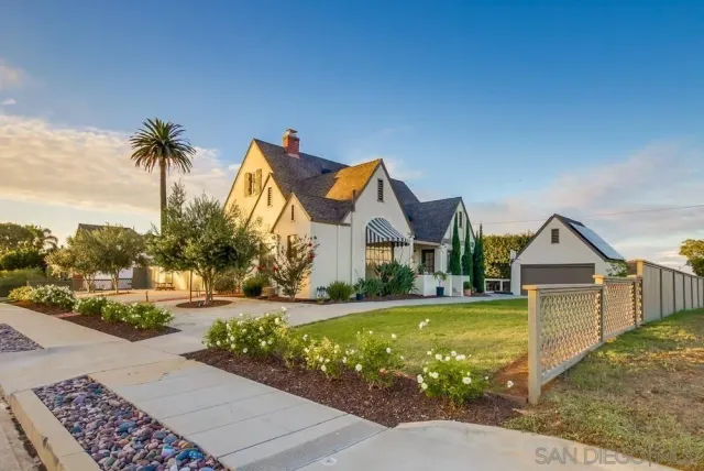 a view of a house with a yard and potted plants