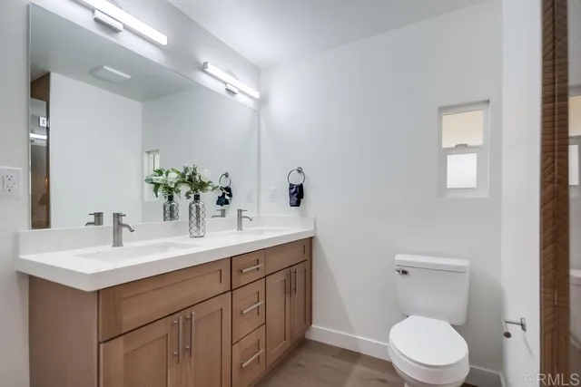 a bathroom with a toilet a sink a mirror and vanity