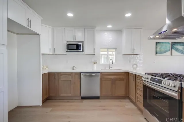a kitchen with stainless steel appliances granite countertop a stove a sink and a microwave