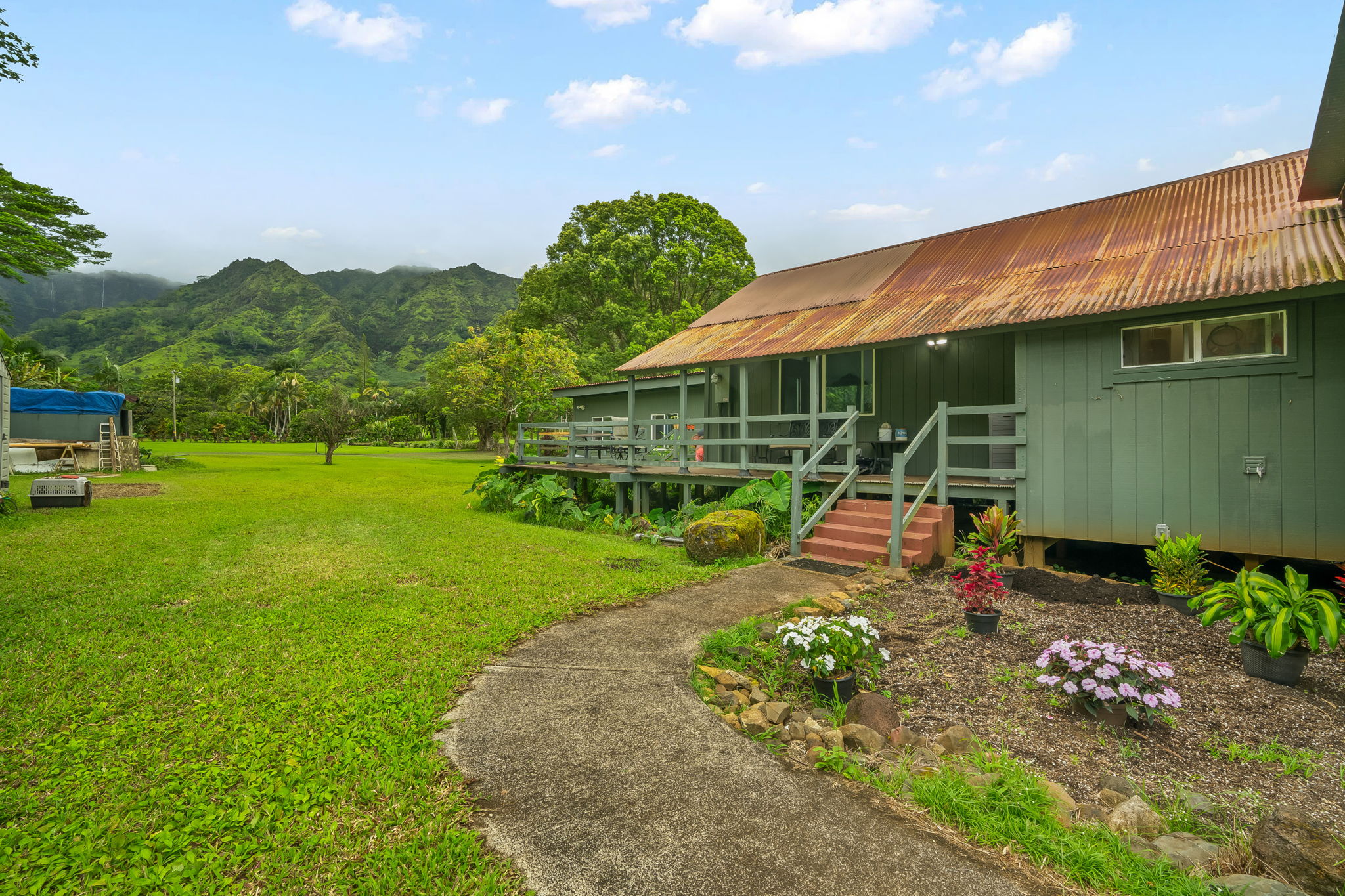 7060 Kahuna Road Kapaa, HI 96746 - Photo 21 of 25 a view of a chair and table in the garden and front view of a house