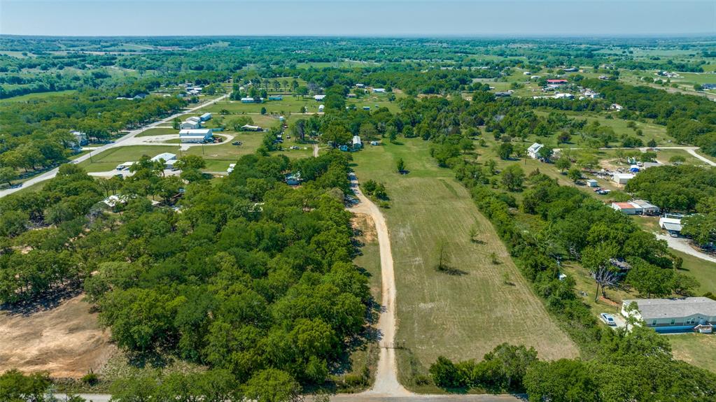 an aerial view of residential houses with outdoor space and trees