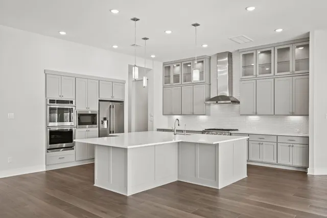 a kitchen with stainless steel appliances granite countertop a sink stove and refrigerator