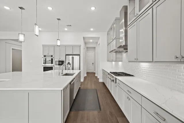 a large white kitchen with stainless steel appliances