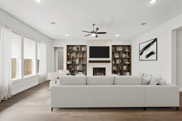 a living room with furniture a fireplace and a large window