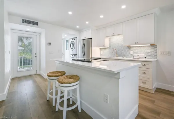 a kitchen with a table chairs a sink and cabinets
