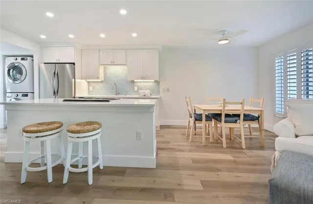 a view of a dining room with furniture and kitchen view