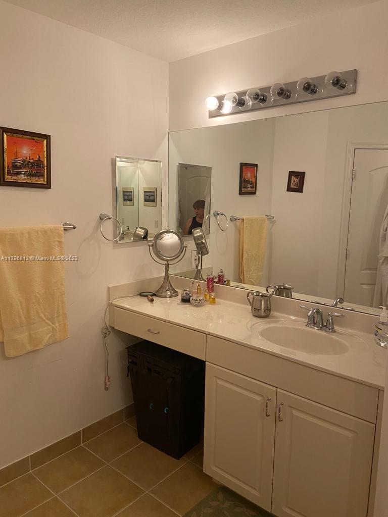 7765 Paddock Place, Unit 7765 Davie, FL 33328 - Photo 13 of 40 a bathroom with a double vanity sink a mirror and shower