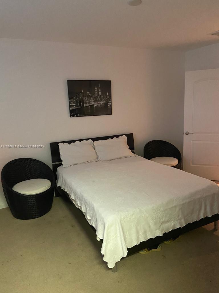 7765 Paddock Place, Unit 7765 Davie, FL 33328 - Photo 16 of 40 a bedroom with a bed and a chair