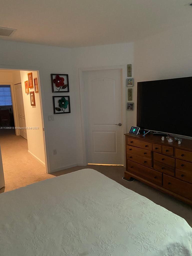 7765 Paddock Place, Unit 7765 Davie, FL 33328 - Photo 17 of 40 a bedroom with furniture and flat screen tv