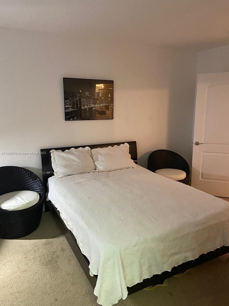 7765 Paddock Place, Unit 7765 Davie, FL 33328 - Photo 19 of 40 a bedroom with a bed and painting on the wall