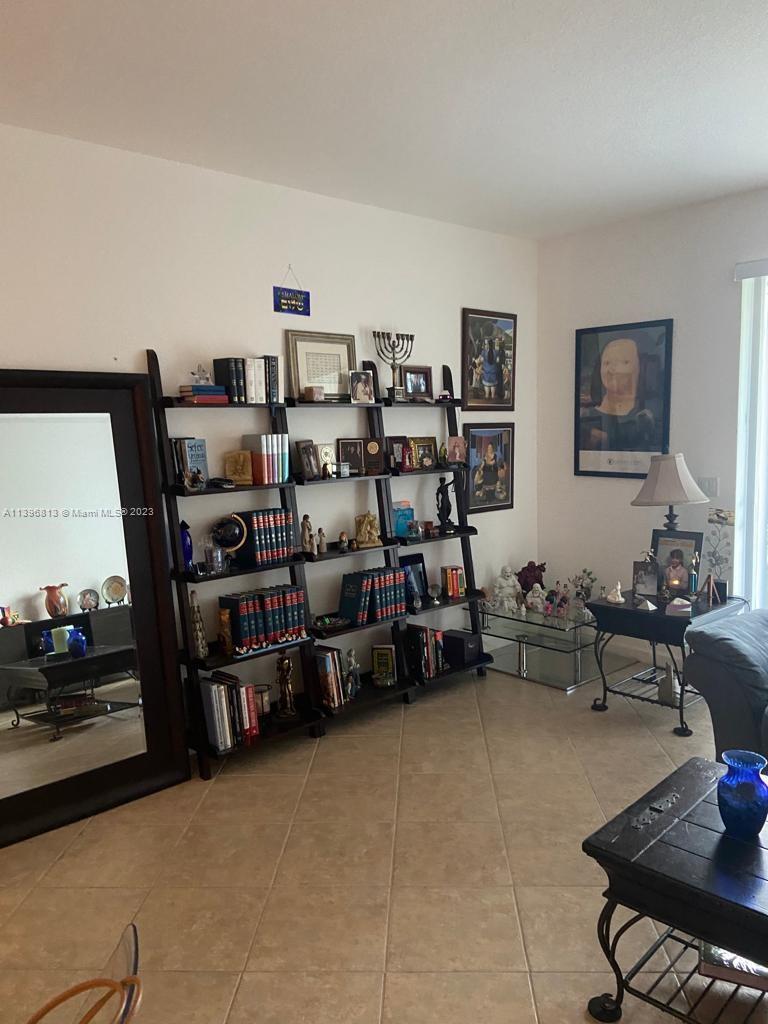 7765 Paddock Place, Unit 7765 Davie, FL 33328 - Photo 27 of 40 a living room with lots of furniture and baby bed