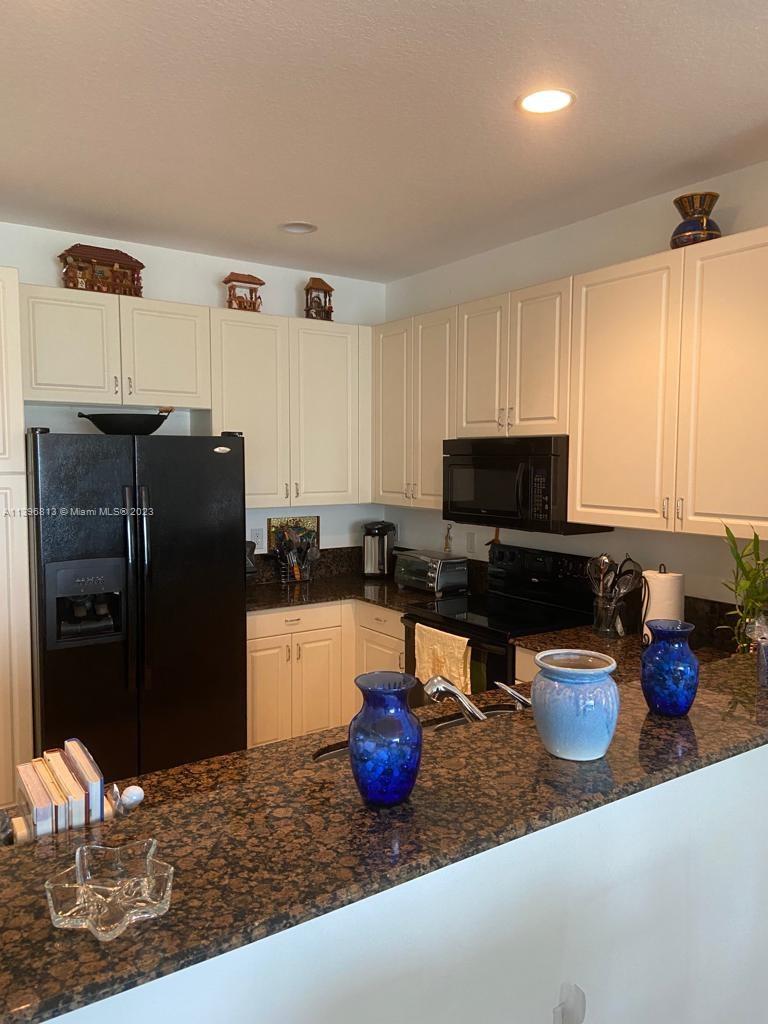 7765 Paddock Place, Unit 7765 Davie, FL 33328 - Photo 8 of 40 a kitchen with a refrigerator and a sink