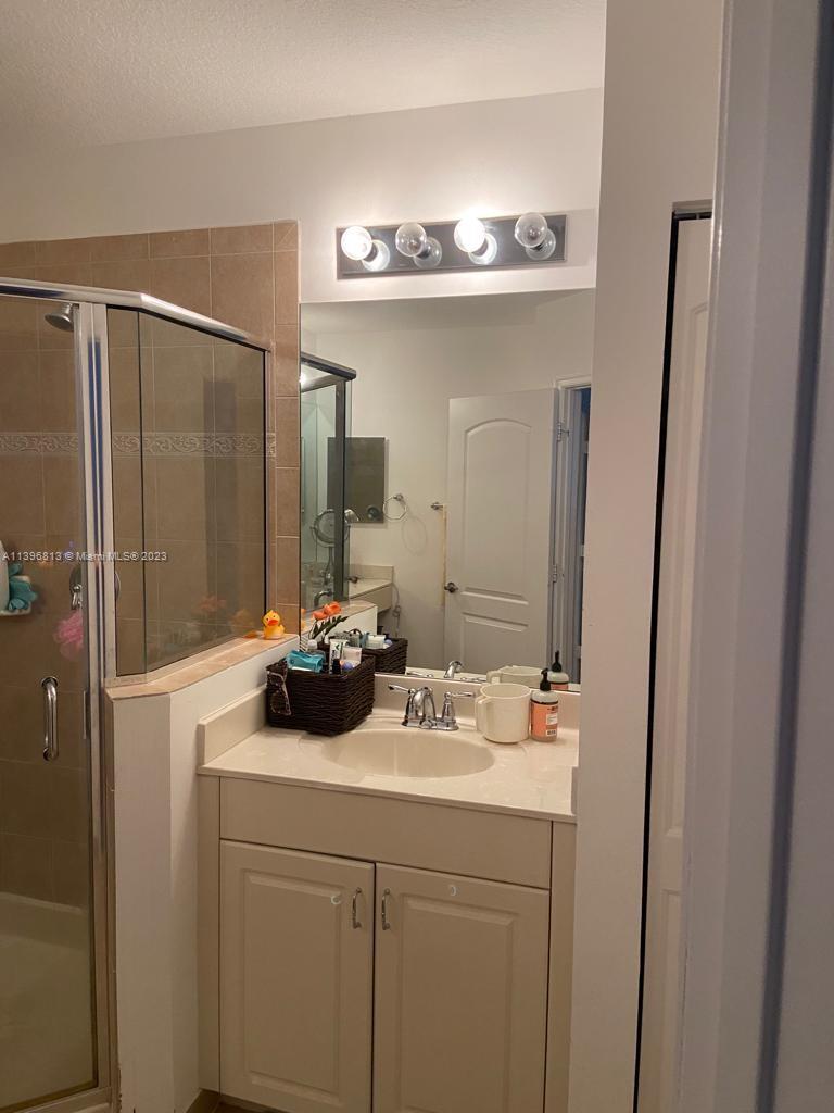 7765 Paddock Place, Unit 7765 Davie, FL 33328 - Photo 9 of 40 a bathroom with a sink a mirror and a shower