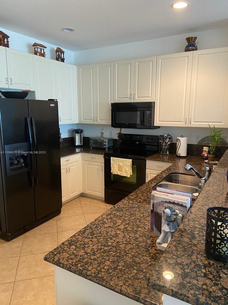 7765 Paddock Place, Unit 7765 Davie, FL 33328 - Photo 10 of 40 a kitchen with granite countertop a refrigerator sink and stove
