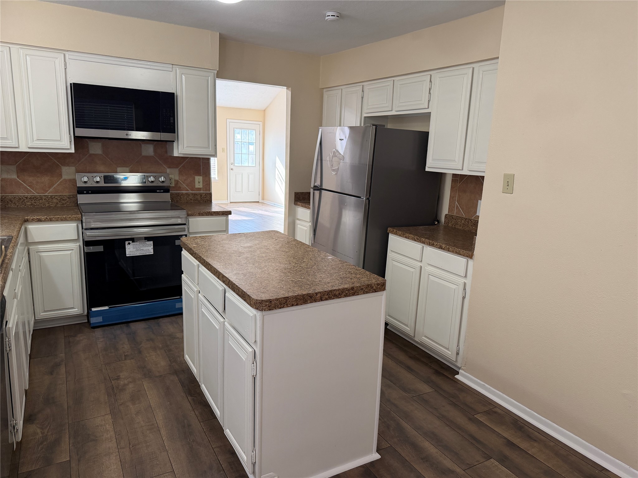 a kitchen with a refrigerator and a stove top oven