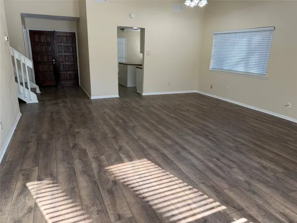 a view of empty room with wooden floor
