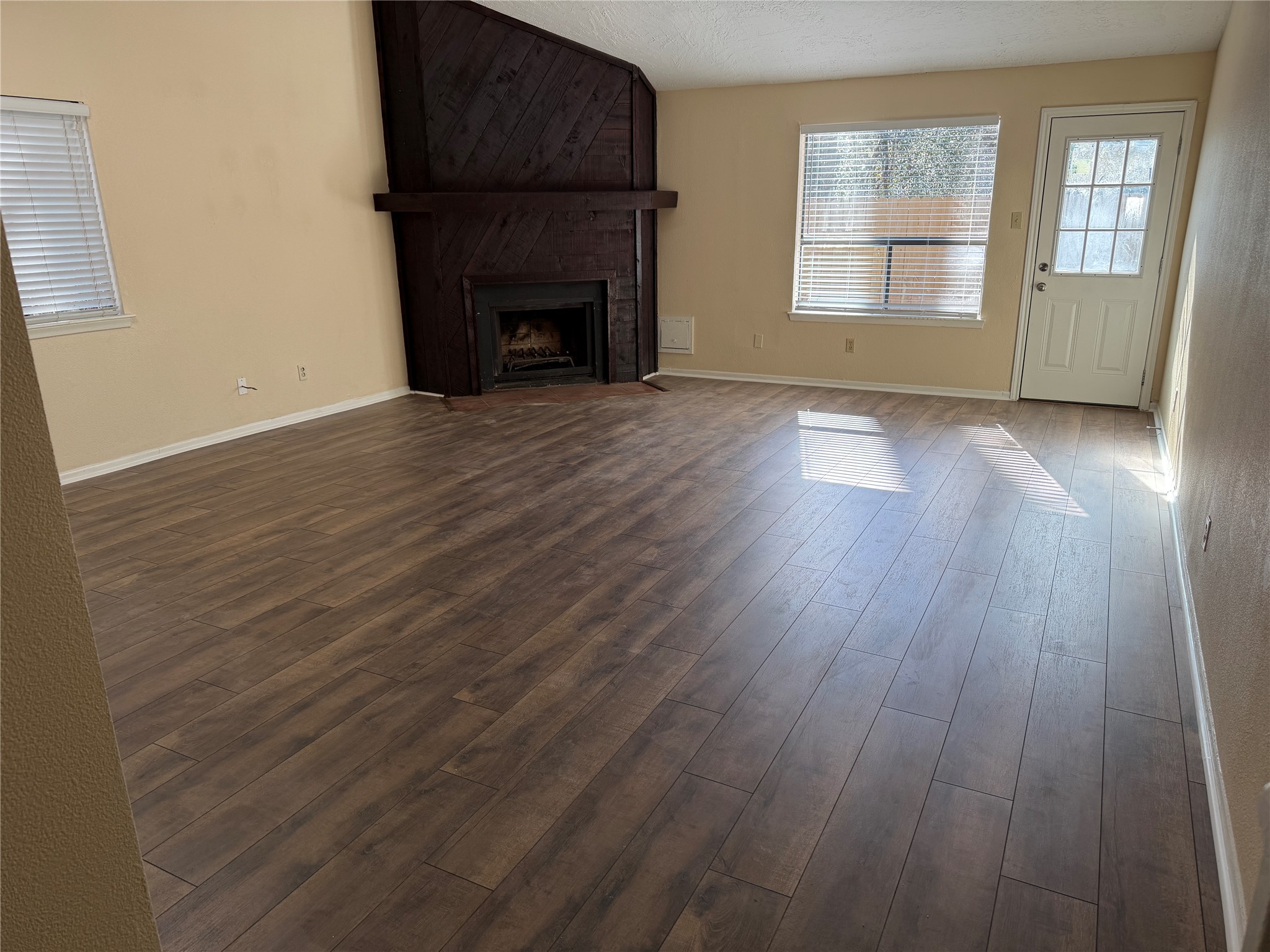 9 Dewthread Court Spring, TX 77380 - Photo 3 of 24 an empty room with wooden floor fireplace and windows